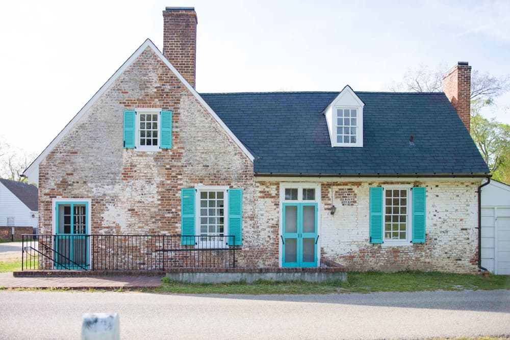 distressed brick bright turqoise trim old house